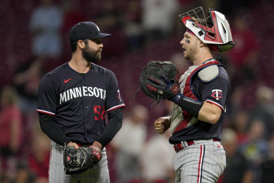 Minnesota Twins relief pitcher Dylan Floro (58) celebrates with catcher Ryan Jeffers following a baseball game against the Cincinnati Reds in Cincinnati, Tuesday, Sept. 19, 2023. (AP Photo/Jeff Dean)