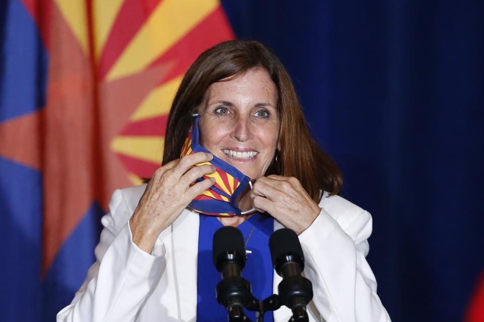 FILE - In this Tuesday, Aug. 11, 2020 file photo, Sen. Martha McSally, R-Ariz., smiles as she removes her face covering to speak prior to Vice President Mike Pence arriving to speak at the "Latter-Day Saints for Trump" coalition launch event in Mesa, Ariz. McSally has suggested that supporters could “fast a meal" to donate to the Arizona Republican's campaign as she fights to fend off a tough challenge from Democrat Mark Kelly in the November 2020 election. (AP Photo/Ross D. Franklin)