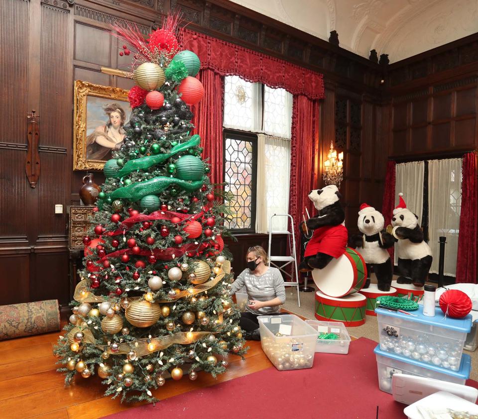 Stan Hywet curator Julie Frey decorates a tree in the Music Room.