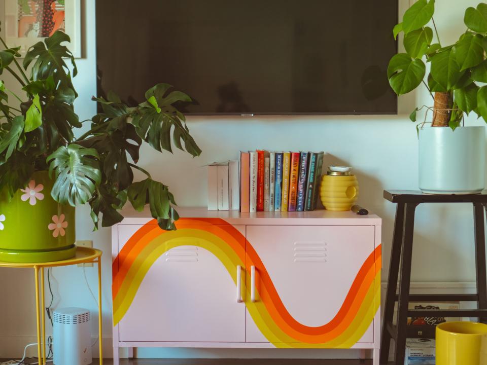 A pink locker cabinet with an orange and yellow rainbow decal on it