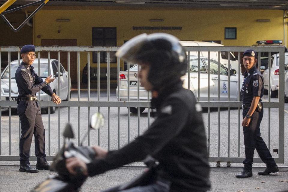 Malaysian police officers guard the gate of the forensic department at Kuala Lumpur Hospital in Kuala Lumpur, Malaysia, Monday, Feb. 20, 2017. Investigators are looking for four North Korean men who flew out of Malaysia the same day Kim Jong Nam, the North Korean ruler's outcast half brother, apparently was poisoned at an airport in Kuala Lumpur, Malaysian police said Sunday. Since Kim's death last week, authorities have been trying to piece together details of what appeared to be an assassination. (AP Photo/Alexandra Radu)