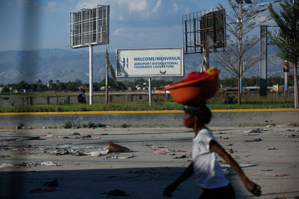 A pedestrian walks past the international airport in Port-au-Prince, Haiti, Monday, March 4, 2024. Gang members exchanged gunfire with police and soldiers around the airport in the latest of a series of attacks on government sites, which includes a mass escape from the country’s two biggest prisons. (AP Photo/Odelyn Joseph)