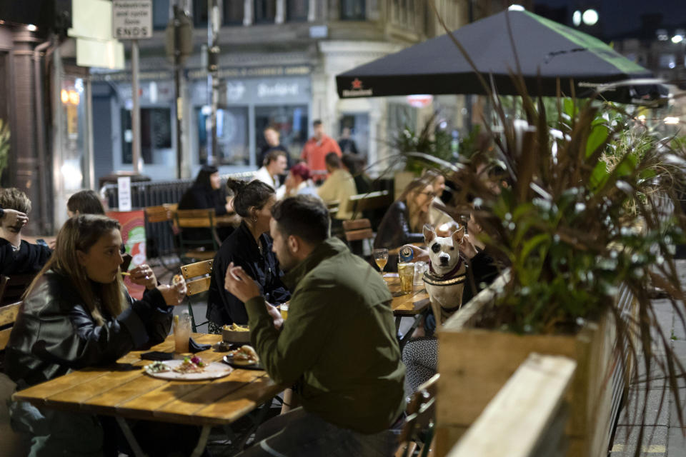 Members of the public are seen at a bar in Manchester's Northern Quarter after Prime Minister Boris Johnson set out new restrictions to last "perhaps six months" to slow the renewed spread of coronavirus, Manchester, England, Tuesday Sept 22, 2020. The UK has reached "a perilous turning point", Boris Johnson said as he set out a raft of new coronavirus restrictions for England. ( AP Photo/Jon Super)