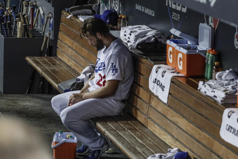 Dodgers pitcher Clayton Kershaw sits by himself in the dugout late in Game 5 of the 2019 NLDS.
