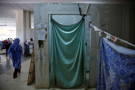 A cloth is used as a screen inside the disused Hellenikon airport, where refugees and migrants are temporarily housed, in Athens, Greece, July 13, 2016. REUTERS/Alkis Konstantinidis/File Photo