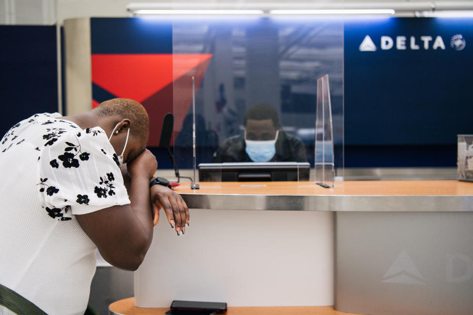 Ein Kunde spricht am 13. Januar 2022 inmitten des anhaltenden Pilotenmangels mit einem Mitarbeiter von Delta Airlines am George Bush Intercontinental Airport. (Foto von Brandon Bell/Getty Images)