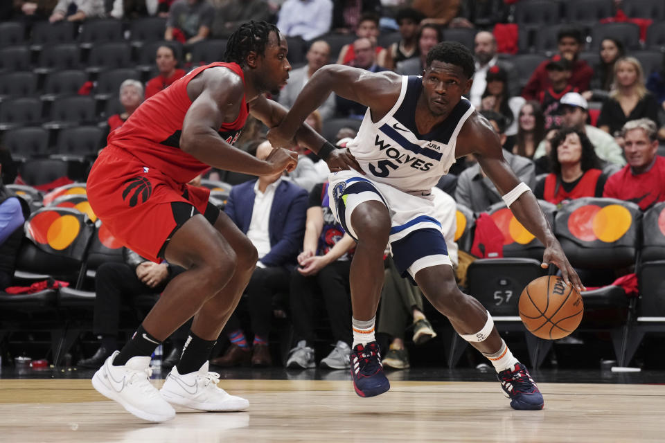 Minnesota Timberwolves' Anthony Edwards (5) protects the ball from Toronto Raptors' O.G. Anunoby (3) during the second half of an NBA basketball game Wednesday, Oct. 25, 2023, in Toronto. (Nathan Denette/The Canadian Press via AP)