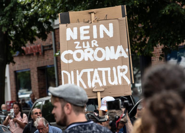 Los participantes marchan con un cartel que dice 'No a la dictadura de la corona' durante una protesta contra el bloqueo del llamado movimiento 'Querdenker' (Pensadores laterales)