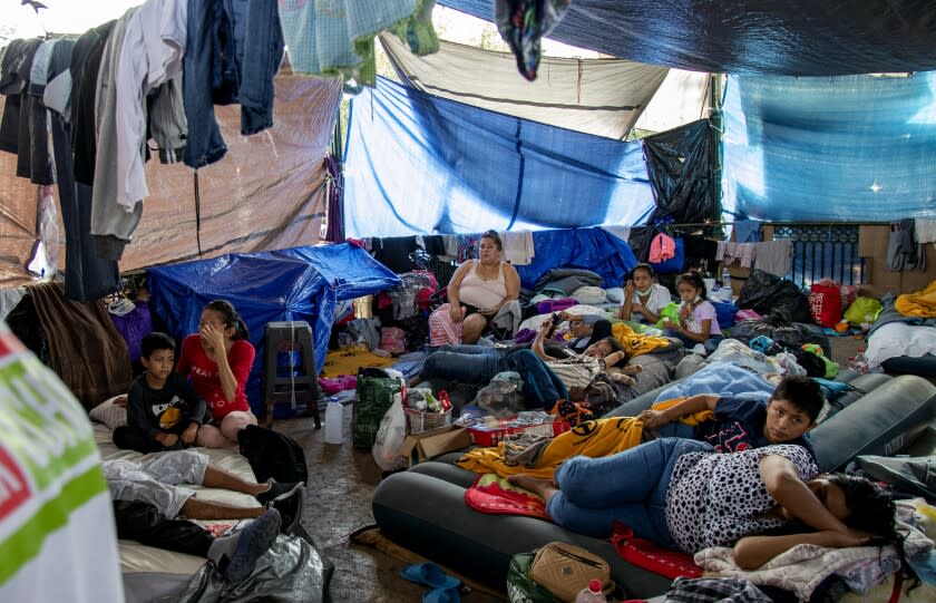 REYNOSA, MEXICO - DECEMBER 6, 2021: Asylum-seeker Maria Jacinto Gomez, 27, of Guatemala, right, sleeps on an air mattress with her 11 year-old son nearby in the crowded gazebo filled with migrants at the Plaza Las Americas migrant tent camp which currently holds 2,000 migrants on December 6, 2021 in Reynosa, Mexico. Gomez and her son have been there for 5 months. Felicia Rangel-Samponaro runs her non-profit Sidewalk School at the tent camp so the children of migrants from Central America and Haiti can learn English and other studies.(Gina Ferazzi / Los Angeles Times)