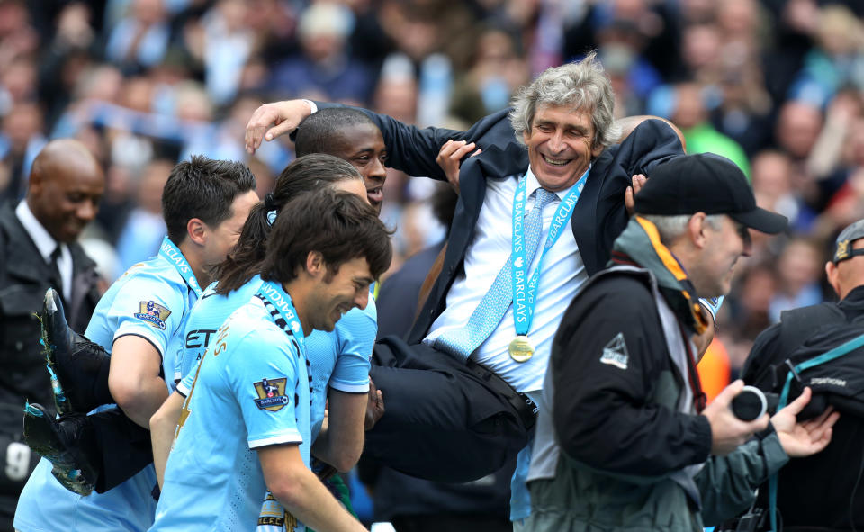 Manchester City's manager Manuel Pellegrini is carried by his players after the English Premier League soccer match between Manchester City and West Ham at the Etihad Stadium in Manchester, England, Sunday May 11, 2014. Manchester City won the Premier League for the second time in three seasons on Sunday, completing its campaign with a comfortable 2-0 victory over West Ham that lacked any of the drama of its previous title. (AP Photo/Jon Super)