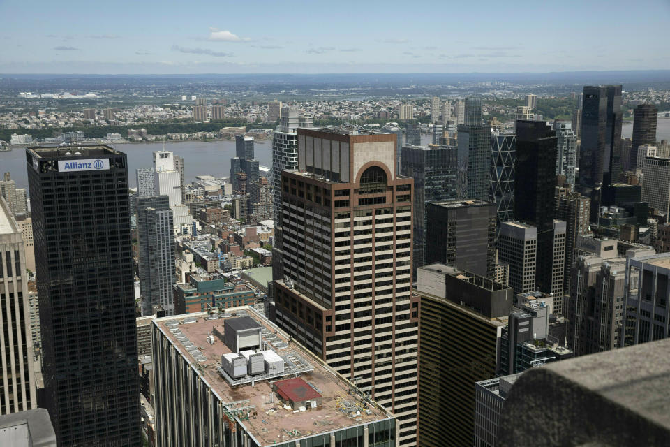 FILE - In this June 11, 2019, file photo, law enforcement personnel work on the roof of the AXA Equitable building, center, in New York. Federal investigators said Tuesday, June 25, 2019, that the pilot killed when his helicopter hit the roof of a New York City skyscraper in rain and fog said before takeoff that radar showed a "20-minute window to make it out." (AP Photo/Mark Lennihan, File)