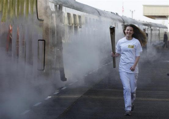 Helana Scott runs with the Olympic torch before boarding a train during the London 2012 Olympic Games Torch Relay rehearsal at Great Central Railway in Leicester, central England April 20, 2012.