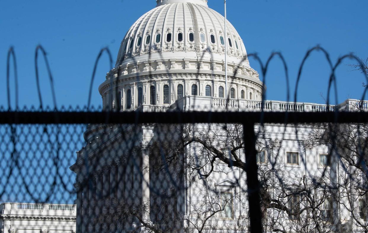 <p>Barbed wire is installed on the top of a security fence surrounding the US Capitol ahead of next week’s inauguration</p> (AFP via Getty Images)