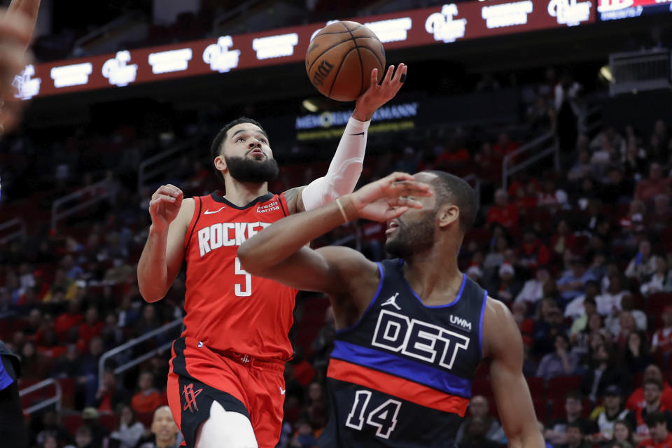 Houston Rockets guard Fred VanVleet, left, lays up a basket over Detroit Pistons guard Alec Burks (14) during the first half of an NBA basketball game, Monday, Jan. 1, 2024, in Houston. (AP Photo/Michael Wyke)