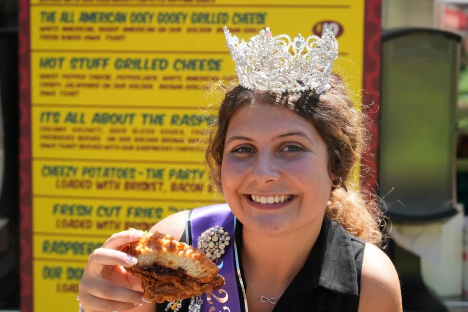 Iowa State Fair Queen Kalayna Durr tries the deep-fried bacon brisket mac-n-cheese grilled cheese, the 2023 People's Choice Best New Food at the Iowa State Fair.