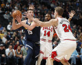 Denver Nuggets center Nikola Jokic, left, looks to pass the ball as Chicago Bulls forwards Wayne Selden Jr., center, and Lauri Markkanen defend in the first half of an NBA basketball game, Thursday, Jan. 17, 2019, in Denver. (AP Photo/David Zalubowski)