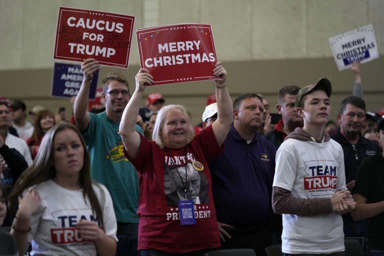 Los miembros de la audiencia reaccionan mientras el expresidente Donald Trump habla durante el mitin en Iowa