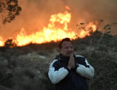 <p>A local man tries to cope and prays during an early-morning Creek Fire that broke out in the Kagel Canyon area in the San Fernando Valley north of Los Angeles, in Sylmar, Calif., Dec. 5, 2017. (Photo: Gene Blevins/Reuters) </p>