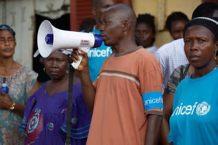 Social mobilizers from NGO Association des Jeunes Conditionnaires et Manutentionnaires (AJCOM), a UNICEF partner, share information on Ebola and best practices to help prevent its spread in Conakry, Guinea, in this handout photo provided by UNICEF taken September 15, 2014. REUTERS/Timothy La Rose/UNICEF/Handout via Reuters