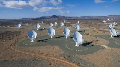 Large white dish-shaped structures in a dry landscape.