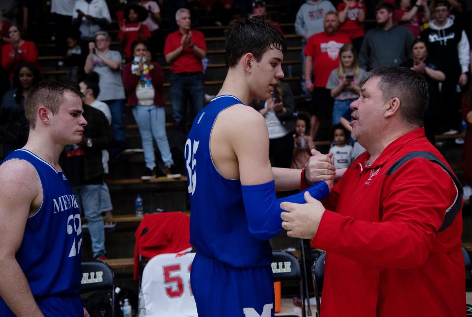 Bosse Head Coach Shane congratulates Memorial's Tucker Tornatta (35) and Connor Agler (22) on their game after their Class 3A sectional championship at Boonville High School Saturday night, March 5, 2022.
