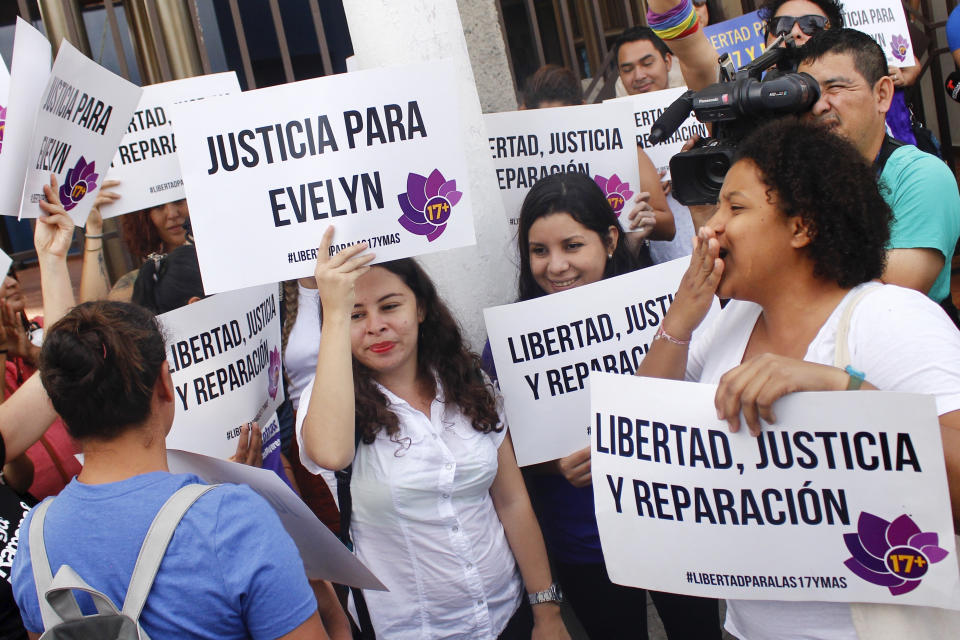 Protestors hold signs calling for justice and freedom for Evelyn Beatriz Hernandez outside the court where she is facing a new trial, after her 30-year sentence for abortion was overturned in February, in Ciudad Delgado, on the outskirts of San Salvador, El Salvador, Monday, July 15, 2019. The young woman who birthed a baby into a toilet in El Salvador faces a second trial for murder Monday, after having already served 33 months, in a case that has drawn international attention because of the country's highly restrictive abortion laws. (AP Photo/Salvador Melendez)