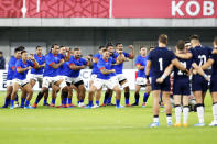 Samoa perform their pre-match challenge the "Siva Tau" in front of Scotland, right, ahead of the Rugby World Cup Pool A game at Kobe Misaki Stadium between Scotland and Samoa in Kobe, western Japan, Monday, Sept. 30, 2019. (Ichiro Sakano/Kyodo News via AP)