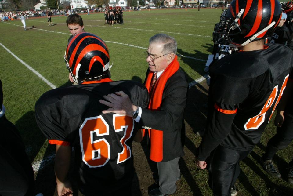 Former coach Boaz Buzz Firkser greets some of the current crop of players at the school were he coached 18 years on the field during celebration of the annual Tenafly - Dumont Thanksgiving Day football game Thursday, November 27, 2003 in Tenafly.