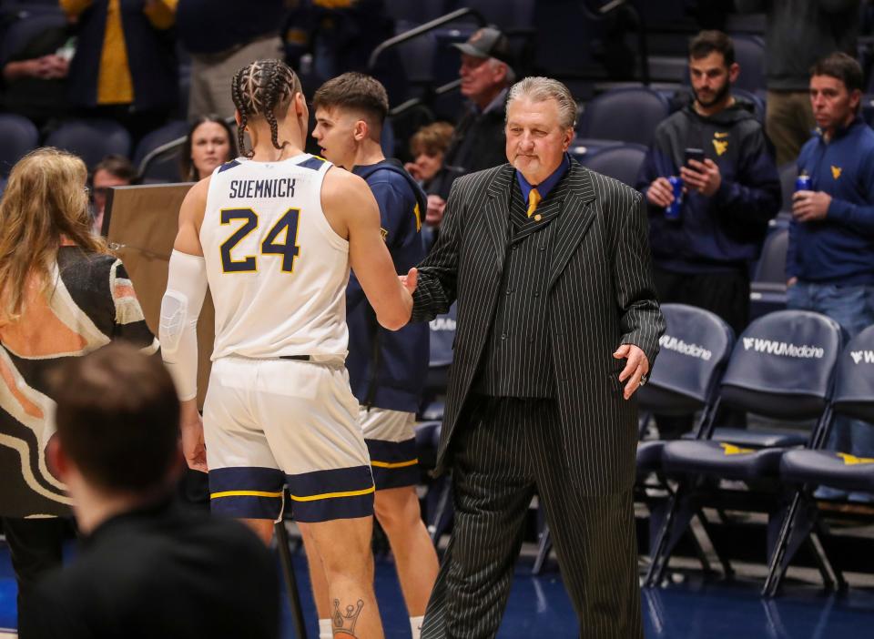 Former West Virginia Mountaineers head coach Bob Huggins greets WVU forward Patrick Suemnick during Senior Day activities