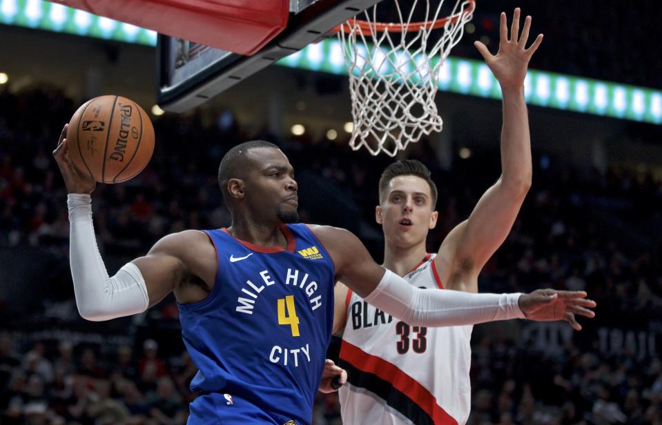 Denver Nuggets forward Paul Millsap, left, looks to pass the ball around Portland Trail Blazers forward Zach Collins during the first half of Game 6 of an NBA basketball second-round playoff series Thursday, May 9, 2019, in Portland, Ore. (AP Photo/Craig Mitchelldyer)