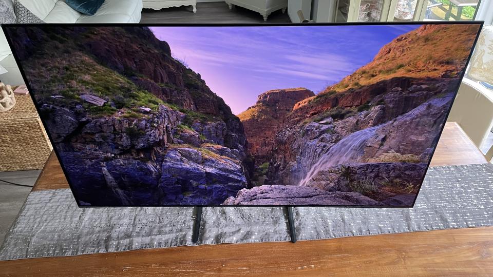 A photo of the Samsung S90C taken from above, displaying a rocky mountain scene