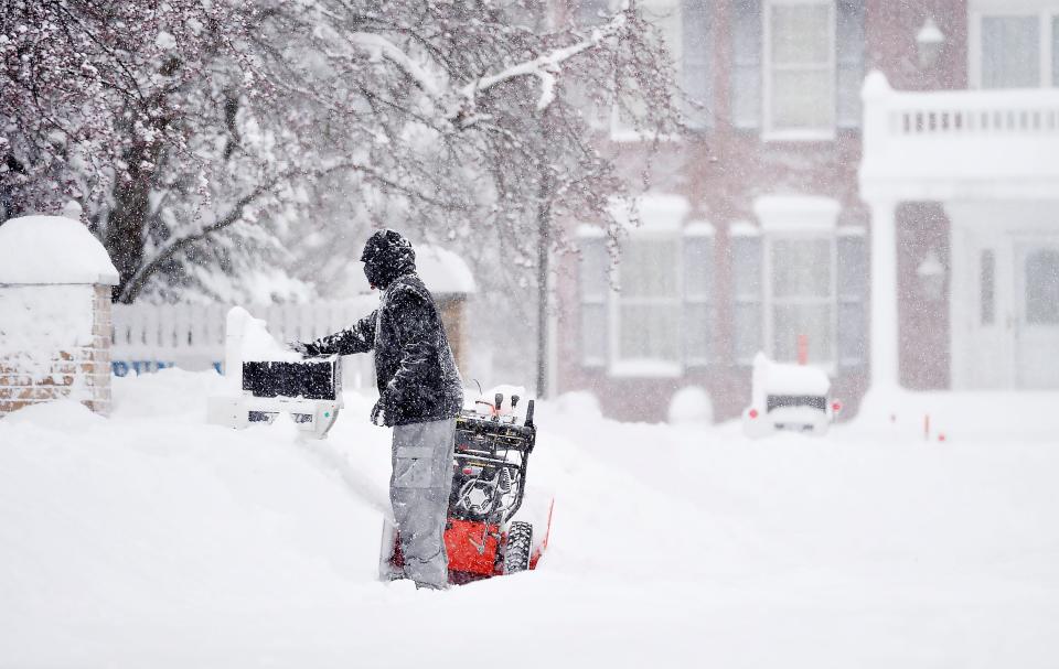 Millcreek Township resident Jay Stubenhofer, 47, clears a neighbor's mailbox on Jan. 17 near Route 5 and Westwood Drive. He cleared a path on the sidewalk earlier and said he did so for his 91-year-old neighbor who "was out doing this himself last year at age 90." A heavy overnight snow greeted motorists at daybreak although schools and some businesses were closed due to the Martin Luther King Jr. holiday, reducing traffic.