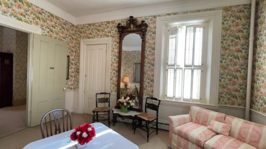 A giant mirror serves as the focal point in a parlor. The two-piece mirror is made of walnut and includes gilt leaf scrollwork.