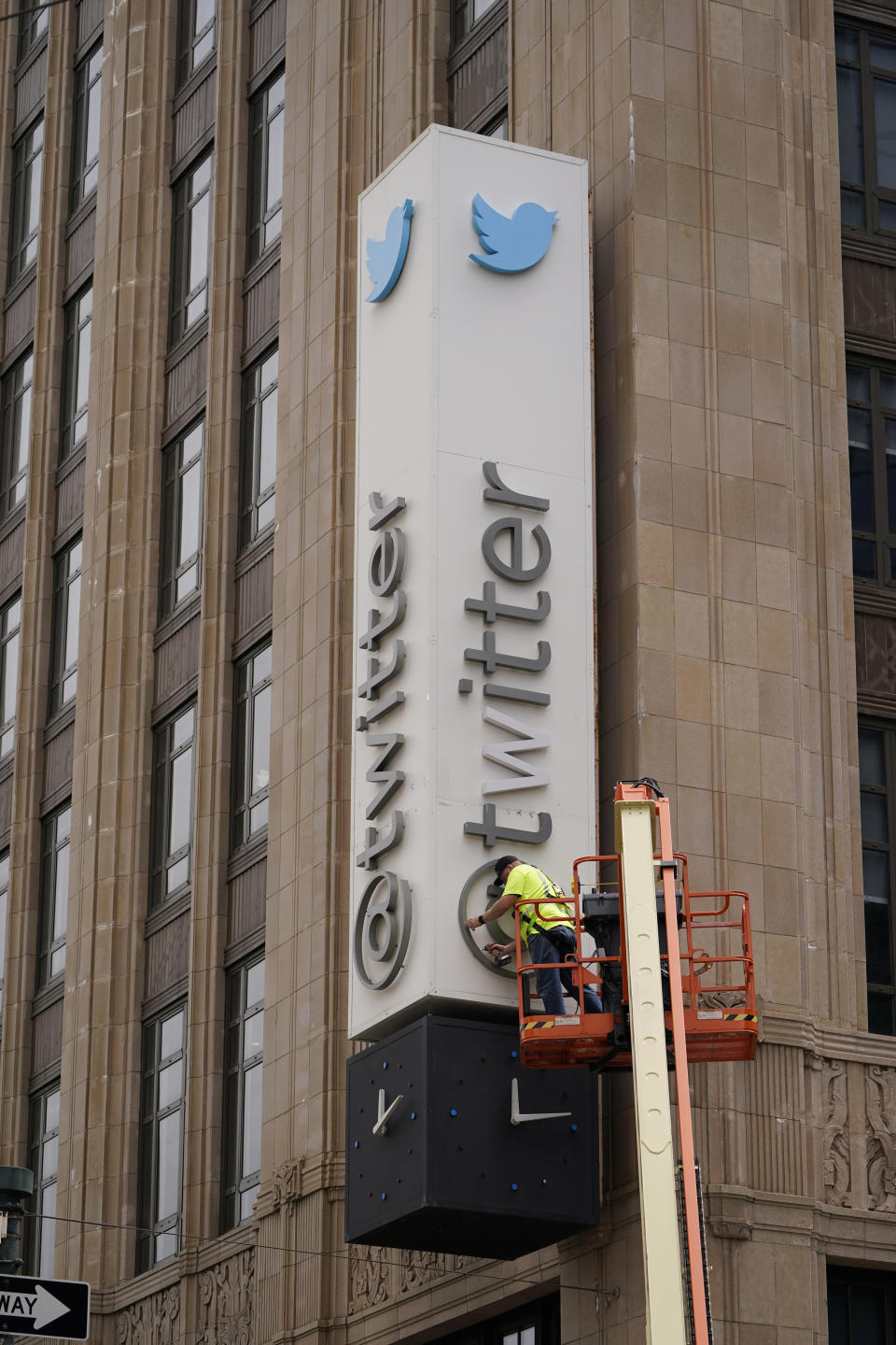 A workman begins removing characters from a sign on the Twitter headquarters building in San Francisco, Monday, July 24, 2023. Elon Musk has unveiled a new "X" logo to replace Twitter's famous blue bird as he follows through with a major rebranding of the social media platform he bought for $44 billion last year. The X started appearing at the top of the desktop version of Twitter on Monday, but the bird was still dominant across the smartphone app. (AP Photo/Godofredo A. Vásquez)