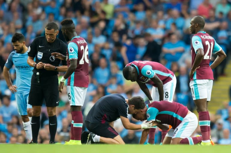 West Ham United's defender Winston Reid, (2ndR), is treated after a clash with Manchester City's striker Sergio Aguero (L) on August 28, 2016