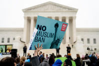 FILE - In this April 25, 2018, file photo, a person holds up a sign that reads "No Muslim Ban" during an anti-Muslim ban rally as the Supreme Court hears arguments about whether President Donald Trump's ban on travelers from several mostly Muslim countries violates immigration law or the Constitution in Washington. Six of Biden's 17 first-day executive orders dealt with immigration, such as halting work on a border wall in Mexico and lifting a travel ban on people from several predominantly Muslim countries. (AP Photo/Andrew Harnik, File)