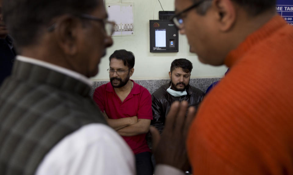 Unidentified relatives wait outside a mortuary to receive bodies of those who died in a hotel fire in New Delhi, India, Tuesday, Feb. 12, 2019. A fire engulfed a shoddily built budget hotel in central New Delhi early Tuesday, killing more than a dozen people. (AP Photo/Manish Swarup)