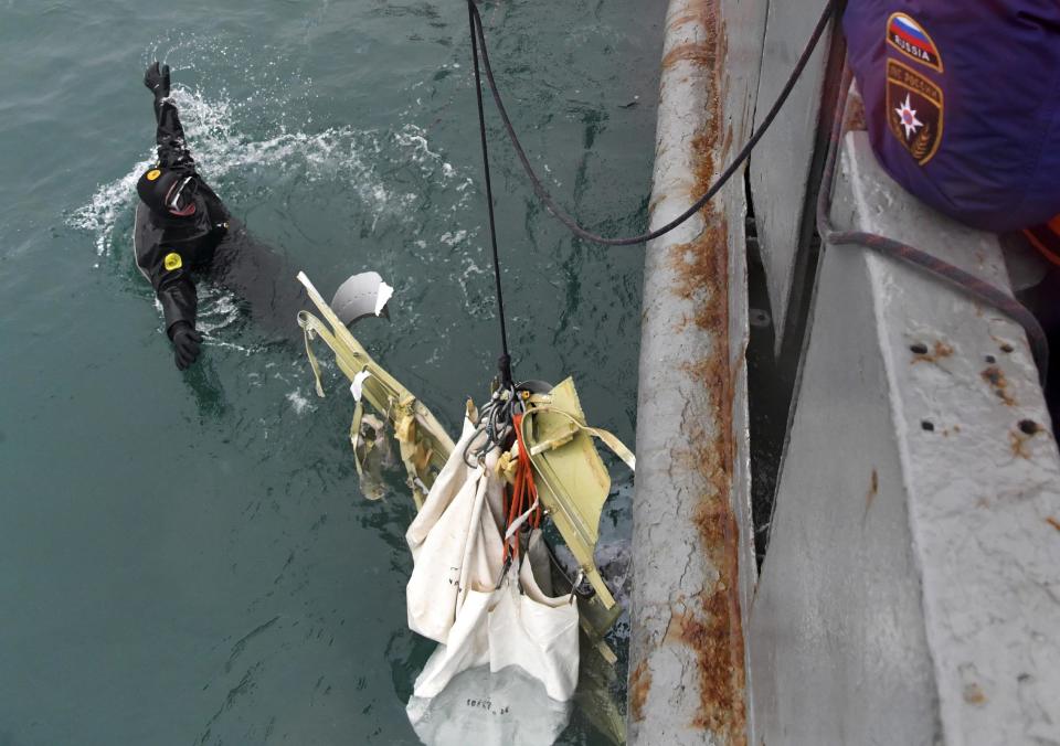 In this photo taken on Wednesday, Dec. 28, 2016 photo provided by the Russian Emergency Ministry Press Service, ministry employees lift a fragment of a plane in the Black Sea, outside Sochi, Russia. Russia's Defense Ministry says search teams have recovered another flight recorder from a military plane that crashed in the Black Sea, killing all 92 aboard. (Vladimir Velengurin/Emergency Situations Ministry Photo via AP)