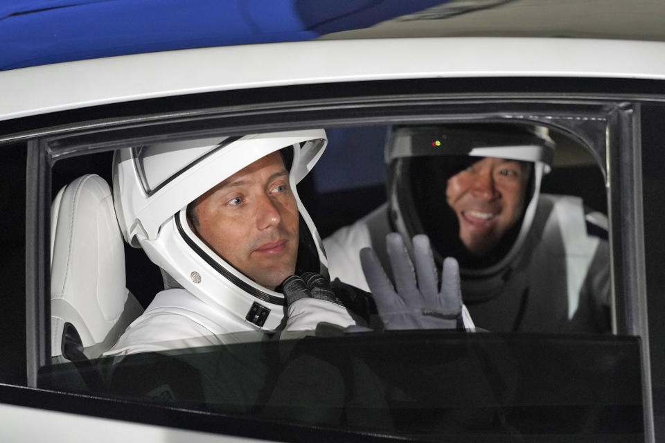 European Space Agency astronaut Thomas Pesquet, of France, left, and Japan Aerospace Exploration Agency astronaut Akihiko Hoshide wave as they leave the operations and checkout building before a launch attempt Friday, April 23, 2021, at the Kennedy Space Center in Cape Canaveral, Fla. Four astronauts will fly on the SpaceX Crew mission to the International Space Station scheduled for launch on April 23, 2021. (AP Photo/John Raoux)