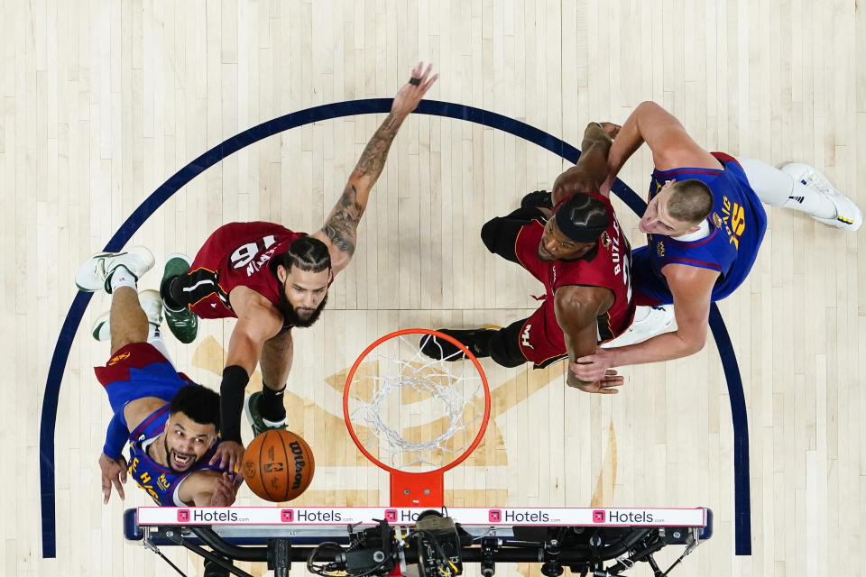 Denver Nuggets guard Jamal Murray, lower left, shoots while defended by Miami Heat forward Caleb Martin (16) during the first half of Game 1 of basketball's NBA Finals, Thursday, June 1, 2023, in Denver. At right are Heat's Jimmy Butler and Nuggets' Nikola Jokic. (AP Photo/Jack Dempsey, Pool)
