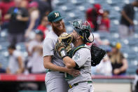 Oakland Athletics relief pitcher A.J. Puk, left, and catcher Stephen Vogt hug after the team's 8-7 win in a baseball game against the Los Angeles Angels Thursday, Aug. 4, 2022, in Anaheim, Calif. (AP Photo/Jae C. Hong)