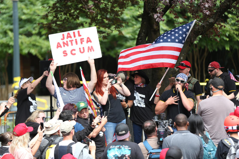 FILE--In this June 30, 2018, file photo, the Patriot Prayer group holds a rally and march in Portland, Ore., amid a protest by anti-fascist groups. Portland is bracing for what could be another round of violent clashes Saturday, Aug. 4, 2018, between a right-wing group holding a rally here and self-described anti-fascist counter-protesters who have pledged to keep Patriot Prayer and other affiliated groups out of this ultra-liberal city. (Mark Graves/The Oregonian via AP, file)