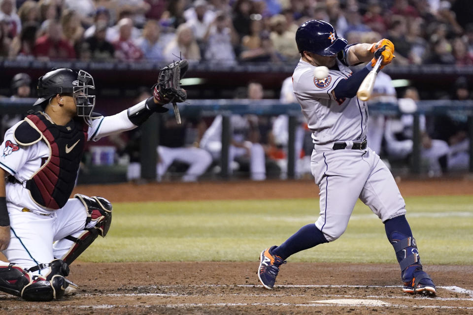 Houston Astros' Jose Altuve, right, strikes out as Arizona Diamondbacks catcher Gabriel Moreno, left, reaches for the ball during the third inning of a baseball game, Saturday, Sept. 30, 2023, in Phoenix. (AP Photo/Ross D. Franklin)