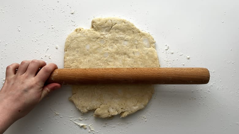 rolling pie crust into a circle with a rolling pin