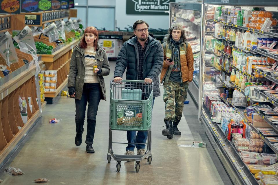 The characters from Don't Look Up walking through a grocery store with many items gone and trash littering the floor