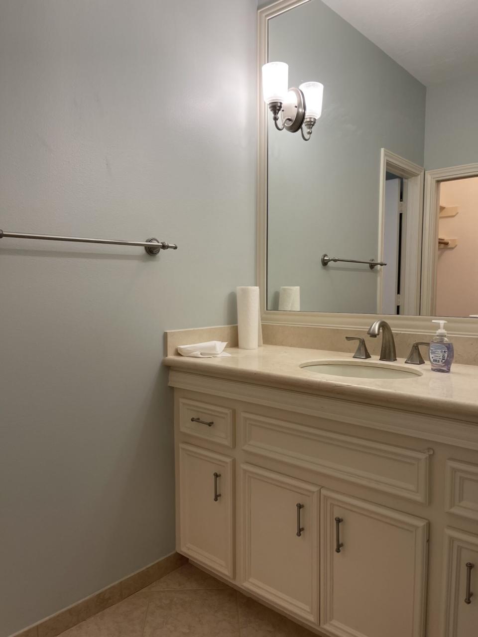 Bathroom before image with beige and white paint and vanity