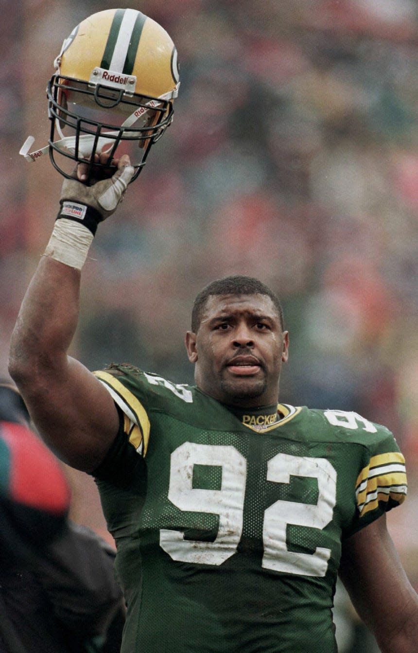 Reggie White acknowledges the crowd as he walks off the field following a 35-28 win over the Chicago Bears on Nov. 12, 1995,