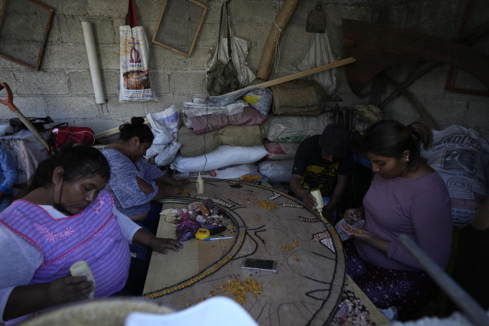Mujeres artesanas crean un mosaico con semillas de maíz nativo, el jueves 15 de junio de 2023 en Ixtenco, México, una ciudad dedicada al cultivo de maíz orgánico. (AP Foto/Fernando Llano)