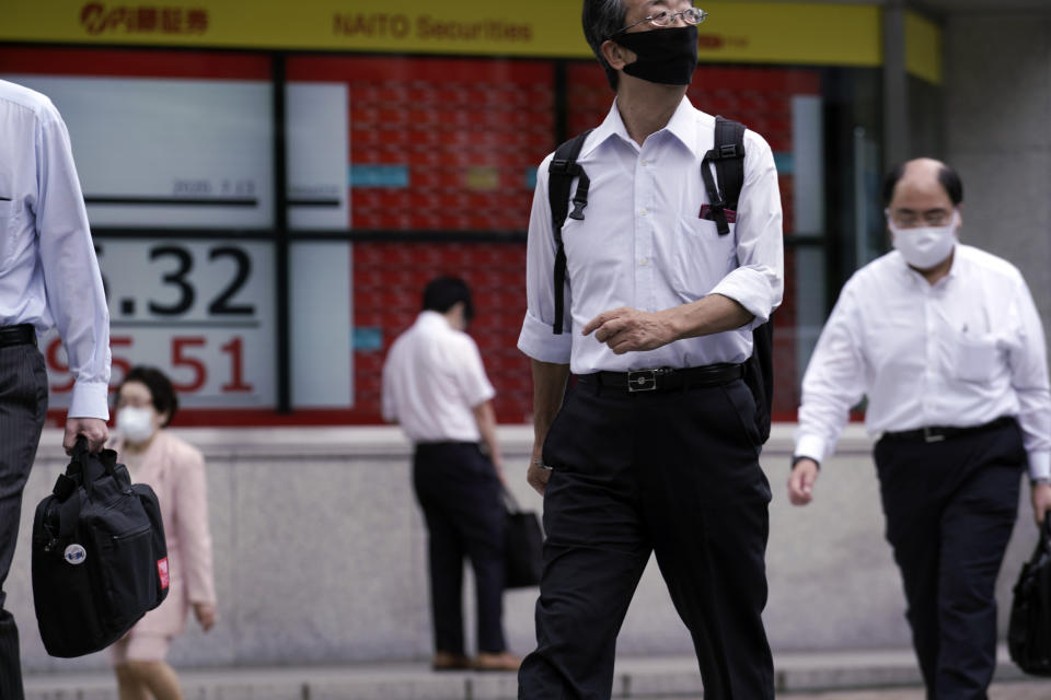 People wearing a face mask to help curb the spread of the coronavirus near an electronic stock board showing Japan's Nikkei 225 index at a securities firm in Tokyo Monday, July 13, 2020. Asian shares rose Monday, cheered by recent upbeat projections on a global rebound tempered with worries about disappointment that could follow. (AP Photo/Eugene Hoshiko)