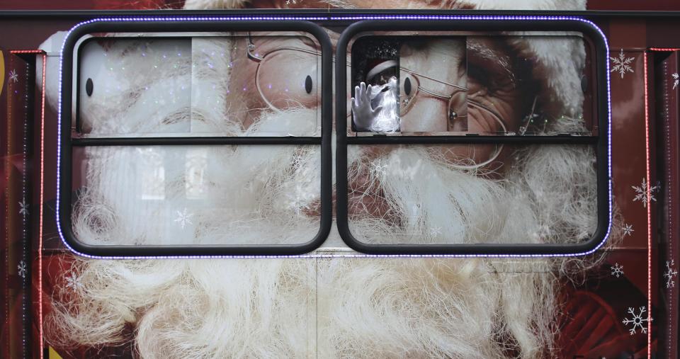 Bus driver Edilson, also known as "Fumassa", poses as he wears a Santa Claus outfit inside an urban bus decorated with Christmas motives in Santo Andre